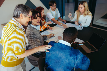 Multicultural class with engaged pupils and supportive teacher during an interactive group activity in a modern classroom setting.