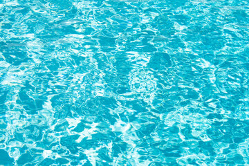Ripple Water in swimming pool with sun reflection. Wavy water background.