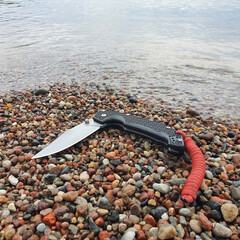 Obraz premium Folding tactical knife designed for survival and military use. Features a sharp mirror edge, durable blade, and ergonomic handle, suitable for outdoor and everyday carry tasks.