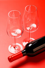 Elegant red wine glasses and a matching red wine bottle