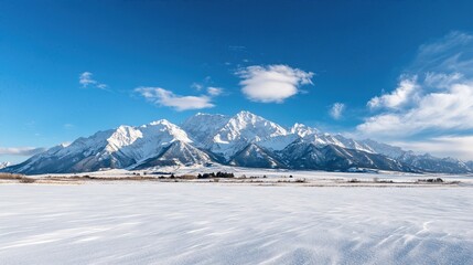 Obraz premium Winter Wonderland: Majestic snow-covered mountains under a vibrant blue sky, serene landscape, crystal-clear air, perfect for winter sports and peaceful escapes.