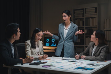 Asian businesspeople having a late night meeting discussing financial reports