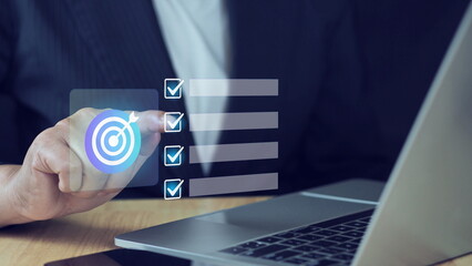 professional interacts with a digital checklist and target icon, representing productivity, goal achievement, and strategic planning.Business goal setting and task management.