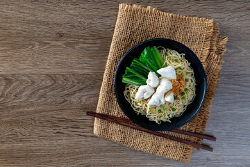 chinese egg noodle in bowl with slice red roasted pork, pork's wontons and white crab meat on it.