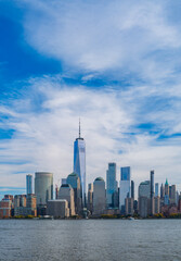 Fototapeta premium New York City cloudy skyline. NYC skyscrapers. Manhattan. NY cityscape with clouds. Downtown New York buildings. NYC skyline on clouds. New York harbor view. Skyscrapers in Manhattan. NYC downtown.