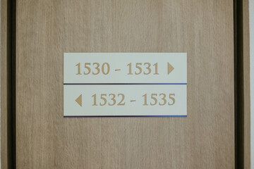 Obraz premium Signage Indicating Room Numbers in a Building Hallway Decor Element