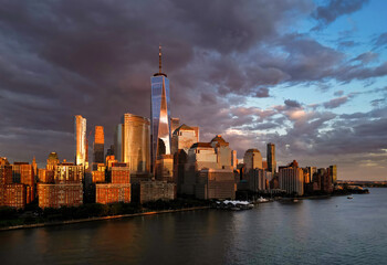 Manhattan aerial skyline, New York. Panorama view of New York city skyscrapers on dramatic sky. USA NYC. Lower NYC skyline on sunset. New York cityscape. New York City with clouds from drone.