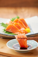 醤油をつけた新鮮なサーモンの刺身