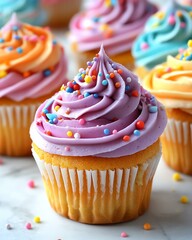 Colorful cupcakes with swirled frosting and vibrant sprinkles on a marble surface.