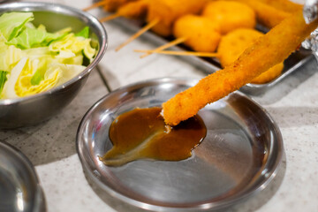 串揚げや串カツをソースにつける