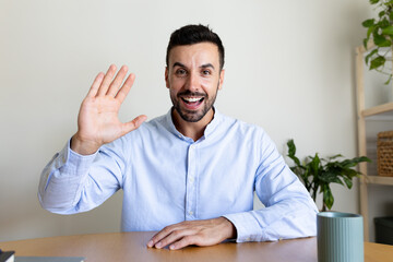 Happy caucasian man looking at camera waving hand saying hello during video call. Screen view.