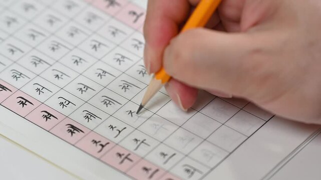 한글 쓰기 연습하는 손과 연습장