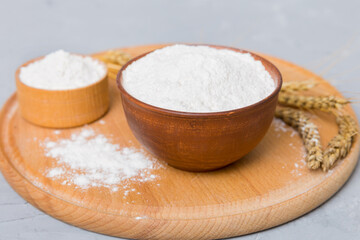 Flat lay of Wheat flour in wooden bowl with wheat spikelets on colored background. world wheat crisis
