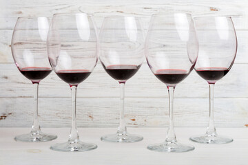 Many glasses of red wine at wine tasting. Concept of red wine on colored background. Top view, flat lay design