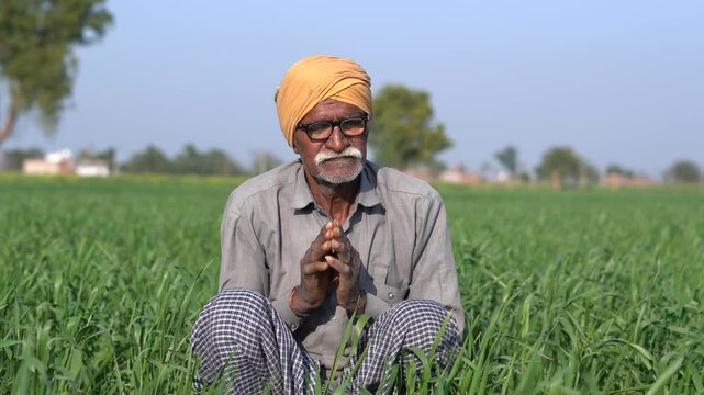 Sad helpless Rural indian farmer sitting at agriculture field pray to god for good crop, Worried Poor Senior farm worker feeling emotional, Village people of india.