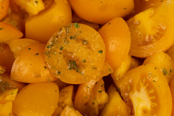 ripe orange tomatoes with spices cut into pieces of different sizes