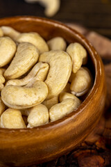 large cashew nuts are scattered on a larch board