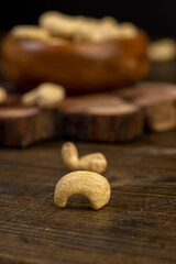 large cashew nuts are scattered on a larch board