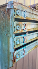  Rusty vintage mailboxes with peeling paint, weathered metal texture, and numbers, showcasing urban decay charm