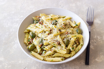 Pasta penne with olives, nuts, herbs and cheese. Healthy food. Italian cuisine. Vegetarian food.