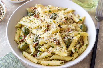 Pasta penne with olives, nuts, herbs and cheese. Healthy food. Italian cuisine. Vegetarian food.