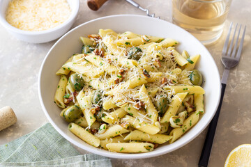 Pasta penne with olives, nuts, herbs and cheese. Healthy food. Italian cuisine. Vegetarian food.
