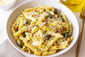 Pasta penne with olives, nuts, herbs and cheese. Healthy food. Italian cuisine. Vegetarian food.