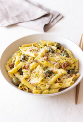 Pasta penne with olives, nuts, herbs and cheese. Healthy food. Italian cuisine. Vegetarian food.