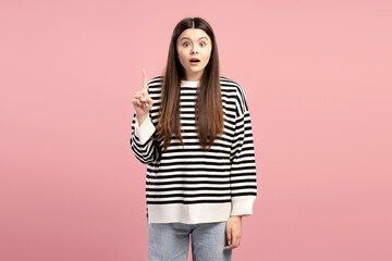 Young girl having an idea raising index finger on pink background