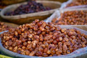 A close-up view of fresh and dried dates arranged in baskets at a market stall.