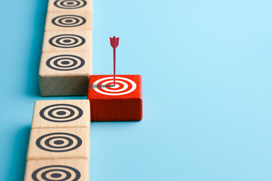 Target audience targeting concept. Red arrow hits a target circle on red wooden cube. Market research. Bulls-eye. Marketing. High advertising efficiency. copy space