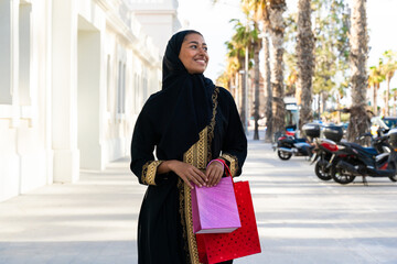 Traditional arab woman wearing abaya outdoors - Beautiful islamic woman strolling in Dubai city