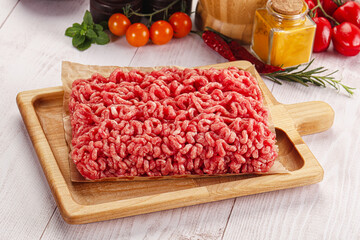 Raw minced beef meat over board