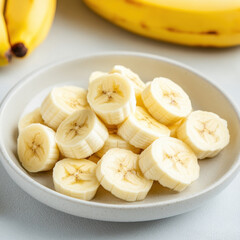 Sliced bananas arranged neatly on plate, showcasing their fresh and vibrant appearance. Perfect for healthy snacks or desserts