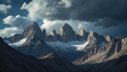 Fototapeta premium Majestic mountain summits beneath a cloudy sky in a secluded wilderness region.