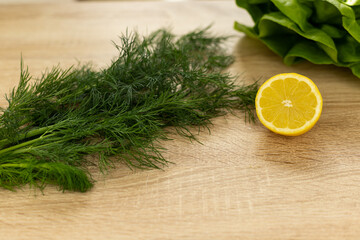 Lemon, dill close-up on the table. Ingredients for salad. Healthy food