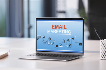 Email marketing website page on laptop screen. Workplace with computer on table