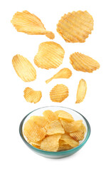 Tasty potato chips falling into bowl on white background