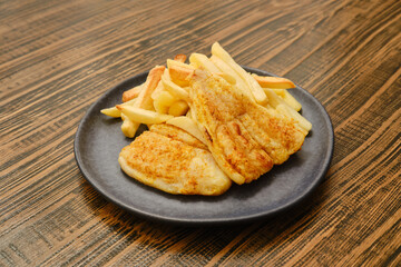 Enjoying a delicious plate of fried fish and crispy fries in a cozy restaurant setting