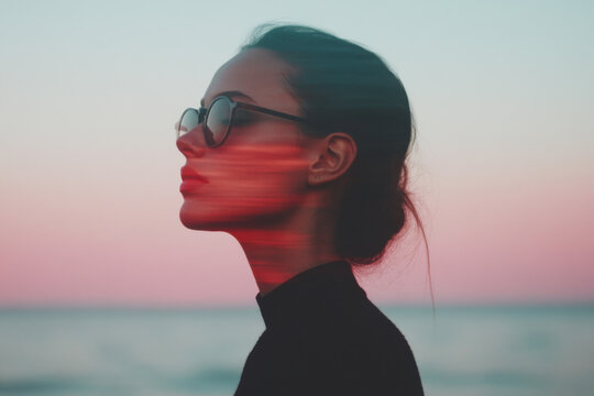 Young woman wearing sunglasses enjoying sunset at beach with double exposure effect