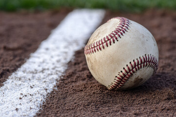 Close-up of a baseball on the field, with white lines and dirt in the background Generative AI	