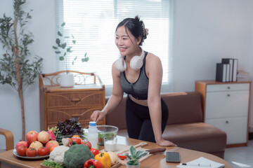 Smiling fitness enthusiast is preparing a healthy salad with fresh vegetables and fruits in the kitchen of her modern apartment, promoting a balanced lifestyle and mindful eating