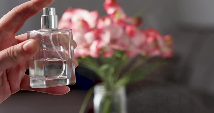 Mist and cloud from perfume sprayed by a woman in a beautiful room with flowers. High quality 4k footage