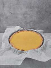 Freshly baked pumpkin pie or lemon tart cooling on baking paper