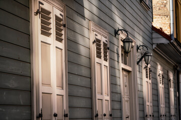 Vintage style wooden window shutters in white color on green wooden building in Riga, Latvia. Retro...