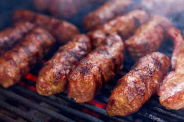 (Mici), traditional Romanian meat dishes on a grill during the cooking process