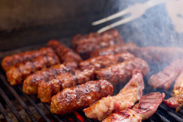 (Mici), traditional Romanian meat dishes on a grill during the cooking process