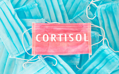 Blue and pink mask with the word Cortisol written on it. Concept of urgency and importance, as...