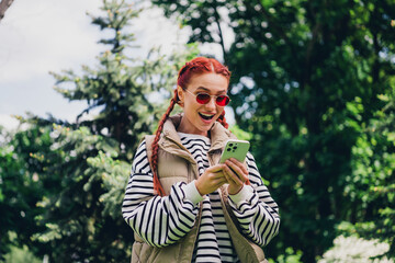 Photo of charming lovely girl wear stylish vest jacket chatting smartphone walk sunny spring weather outdoors