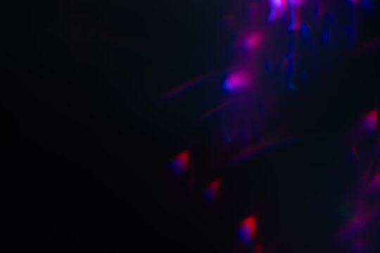 Abstract blurred colorful lens flare bokeh on black,